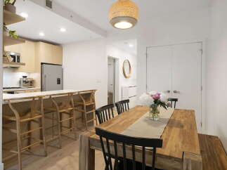 This modern dining area features a spacious wooden table with black chairs, perfect for family meals.