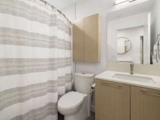 This modern bathroom features a clean white toilet next to a stylish shower curtain with subtle stripes.