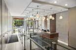 Step into a welcoming lobby featuring a modern reception desk with a live edge wood counter and elegant pendant lighting.