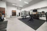 This modern gym features a comprehensive selection of free weights, including a full dumbbell rack, and a variety of cardio machines like treadmills.