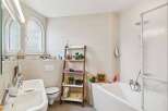 This modern bathroom features a clean and bright aesthetic with light-colored tiled walls and floors.