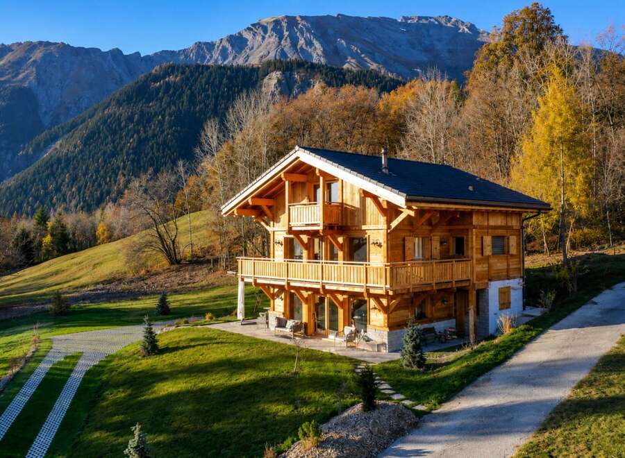 Experience the charm of this stunning wooden chalet nestled amidst the breathtaking autumn scenery of the Alps.