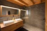 Experience modern luxury in this stunning bathroom featuring a double vanity with sleek rectangular sinks and a spacious walk-in shower with elegant stone tile.