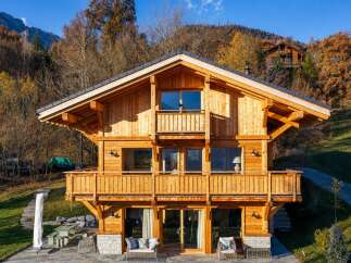 Experience luxury mountain living in this stunning wooden chalet, nestled amidst vibrant autumn foliage.