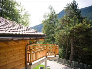 Experience the charm of this mountain retreat, featuring a beautifully crafted wooden exterior and a welcoming balcony perfect for enjoying the serene natural surroundings.