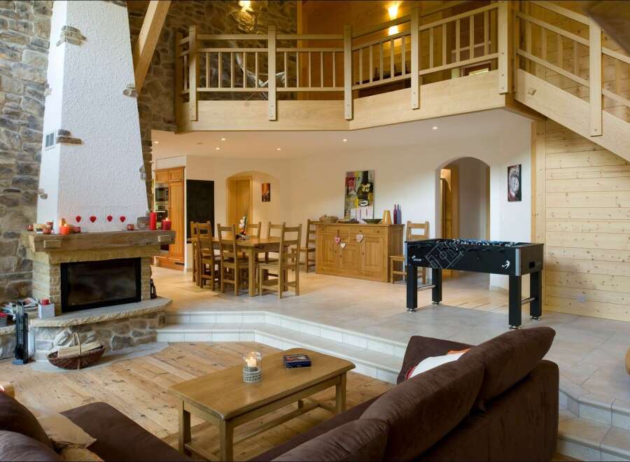 Experience rustic charm and modern comfort in this spacious living area, featuring a grand stone fireplace and an open-concept layout.