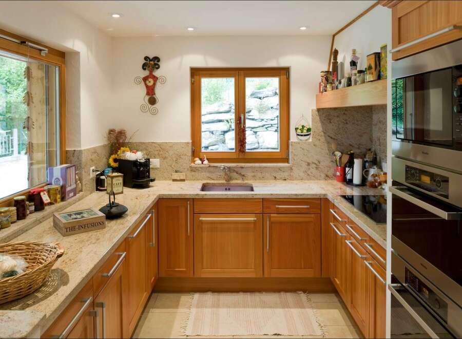 Discover this charming kitchen featuring warm wooden cabinetry and elegant granite countertops.