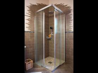 Experience modern luxury in this stunning bathroom featuring a spacious corner shower with frosted glass doors and a sleek chrome frame.