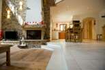 Experience rustic charm in this open-concept living space, featuring a magnificent stone fireplace as the centerpiece.