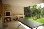 Enjoy outdoor living with this covered patio featuring a stone fireplace and built-in counter space, perfect for entertaining.