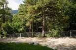 Discover this property featuring a paved driveway leading to a lush green lawn, bordered by a modern metal fence.