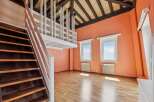 Discover this charming attic space featuring a rustic wooden staircase leading to a loft area with white railings.