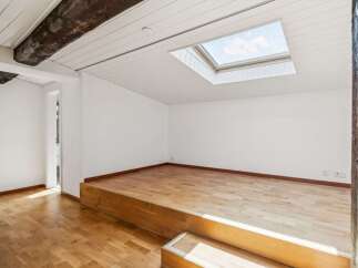 Discover this unique space featuring a raised wooden platform, perfect for a bedroom or lounge area.