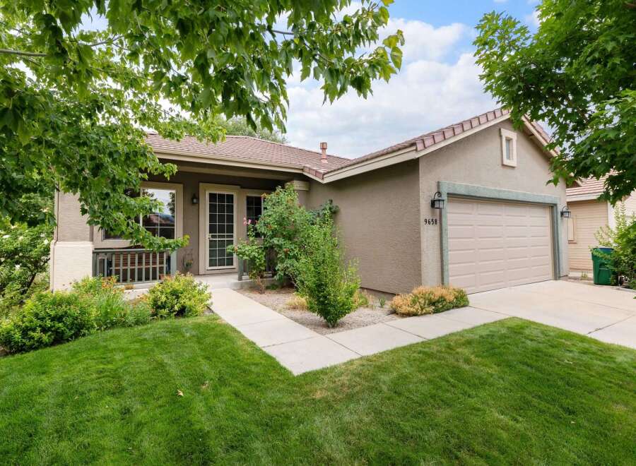 Charming single-story home with a welcoming facade, featuring a well-maintained lawn and mature trees.