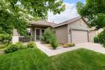 Charming single-story home with a welcoming facade, featuring a well-maintained lawn and mature trees.