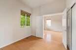 This bright and airy room features a large window with a view of lush greenery, flooding the space with natural light.
