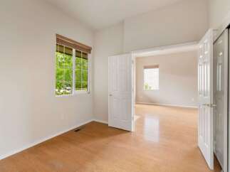 This bright and airy room features a large window with a view of lush greenery, flooding the space with natural light.