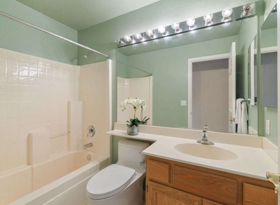 This bathroom features a clean and functional design with a bathtub and shower combination, a white toilet, and a vanity with a sink.