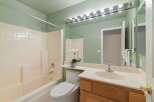 This bathroom features a clean and functional design with a bathtub and shower combination, a white toilet, and a vanity with a sink.