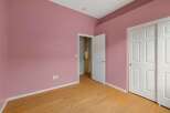 Step into this charming room featuring a soft pink accent wall, creating a warm and inviting atmosphere.