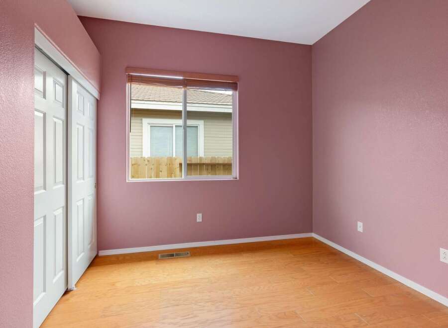 This charming room features a fresh coat of pink paint on its textured walls, creating a warm and inviting atmosphere.