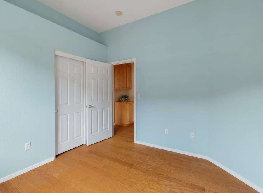 This room features a light blue painted wall and a polished hardwood floor, creating a bright and airy atmosphere.