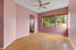 Experience comfort and style in this charming room featuring soft pink walls and gleaming hardwood floors.