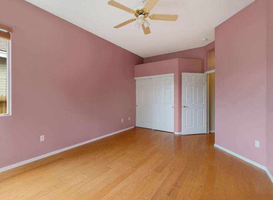 Discover this charming bedroom featuring a spacious layout and a soothing pink color palette.