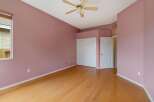 Discover this charming bedroom featuring a spacious layout and a soothing pink color palette.