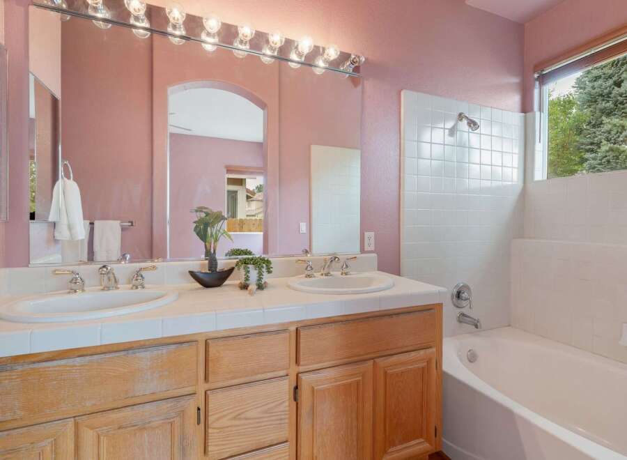 This charming bathroom features a dual vanity with ample counter space and elegant chrome fixtures, perfect for busy mornings.