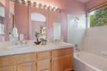 This charming bathroom features a dual vanity with ample counter space and elegant chrome fixtures, perfect for busy mornings.