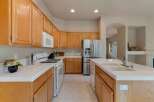 This spacious kitchen features beautiful light wood cabinetry and a large stainless steel refrigerator.