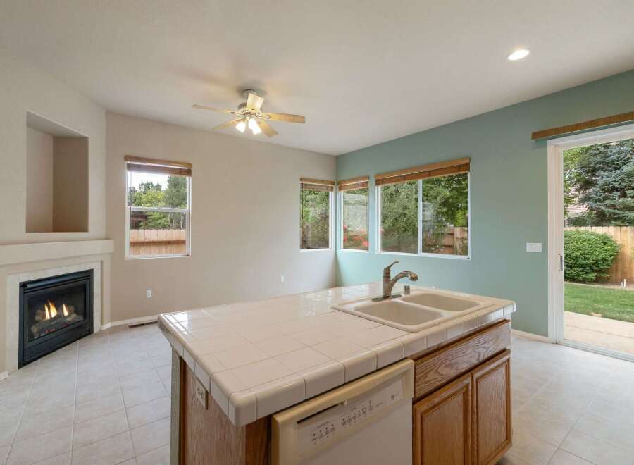 This spacious kitchen features a cozy fireplace and a large island with a double sink, perfect for meal preparation and entertaining.