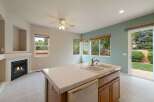 This spacious kitchen features a cozy fireplace and a large island with a double sink, perfect for meal preparation and entertaining.