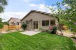 Enjoy outdoor living in this charming backyard featuring a lush green lawn and a concrete patio perfect for entertaining.