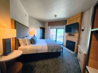Experience ultimate comfort in this luxurious hotel room featuring a king-sized bed with plush bedding and a stylish upholstered headboard.