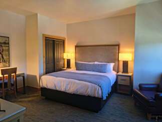 Experience comfort and style in this beautifully appointed hotel room, featuring a plush king-size bed with a striking upholstered headboard.