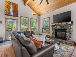 Experience rustic charm in this inviting living room, featuring a grand stone fireplace perfect for cozy evenings.