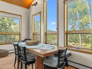 Experience breathtaking mountain views from this charming dining area, bathed in natural light from expansive windows.