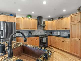Experience luxury in this stunning kitchen featuring a large copper sink and a granite countertop.