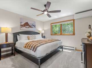 Experience ultimate comfort in this beautifully appointed bedroom, featuring a plush king-size bed adorned with a luxurious faux fur throw.