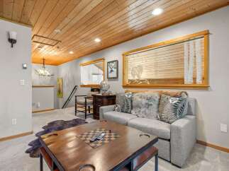Cozy living room featuring a comfortable gray sofa adorned with plush faux fur and decorative pillows, perfect for relaxation.