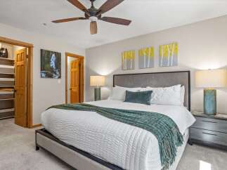 Experience ultimate comfort in this beautifully appointed bedroom, featuring a plush king-size bed adorned with crisp white linens and a cozy teal throw.