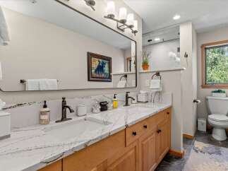 This beautifully appointed bathroom features a spacious double vanity with elegant quartz countertops and modern fixtures, perfect for any morning routine.