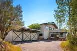 Discover this charming home featuring a distinctive barn-style garage with large double doors, perfect for vehicle storage or a workshop.