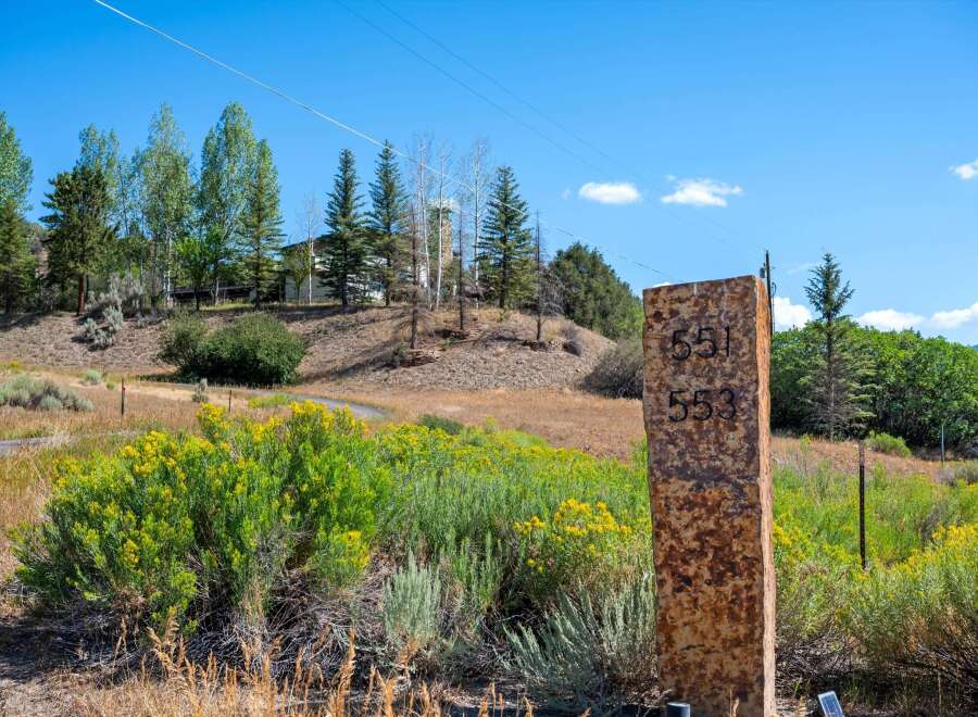 Discover this stunning property with a beautiful stone marker displaying house numbers 551 and 553.