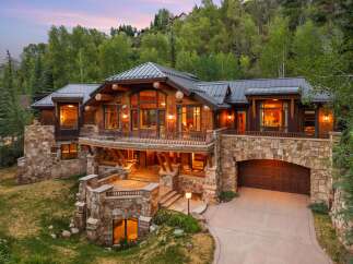 Experience luxury mountain living in this stunning timber and stone estate, nestled amidst lush greenery.