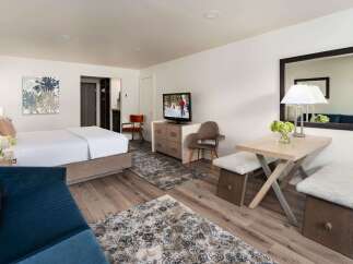 Experience comfort and style in this well-appointed hotel room, featuring a plush king-sized bed and a cozy seating area.