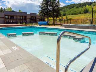 Enjoy a refreshing dip in this stunning outdoor swimming pool, complete with a shallow wading area and built-in seating.