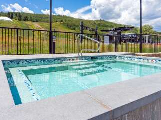 Enjoy a refreshing dip in this stunning spa, featuring crystal-clear water and elegant mosaic tile accents.